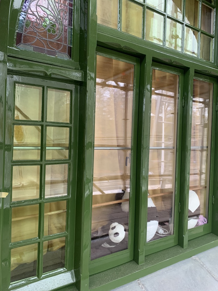 Groen geschilderde kozijnen met origineel glas-in-lood bovenlicht