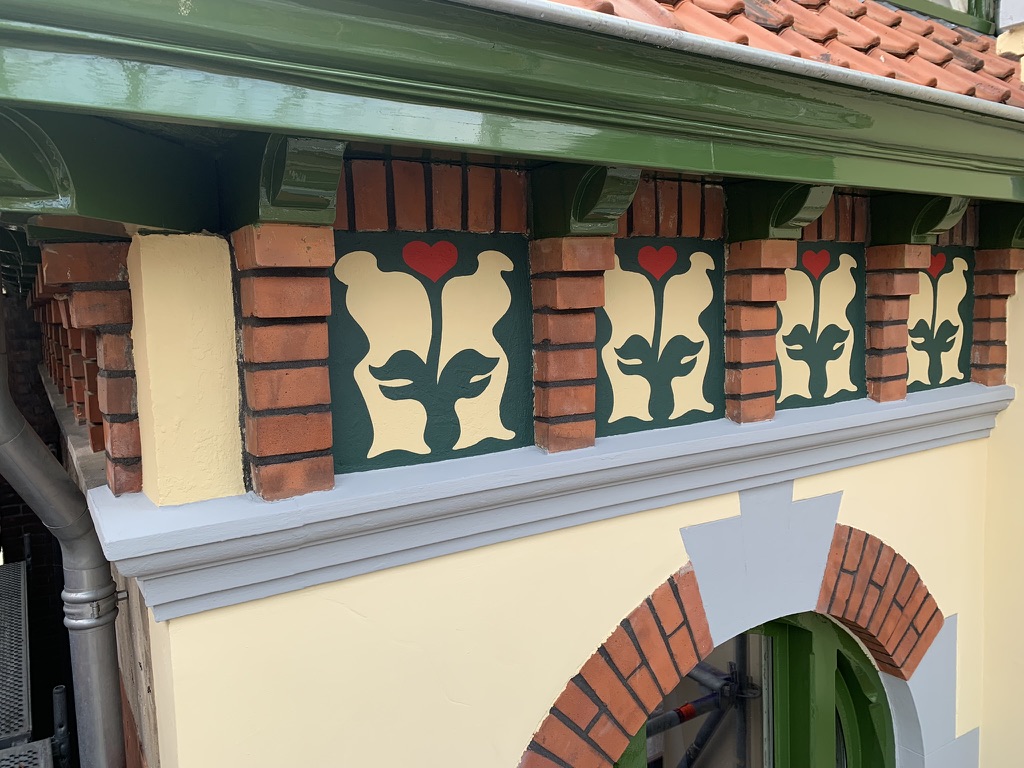 Hartbloem-fries met rode harten en cr&egrave;me bladeren op groene panelen